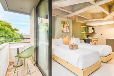 two beds in a room with a balcony at Firenze Lofts in Medellín