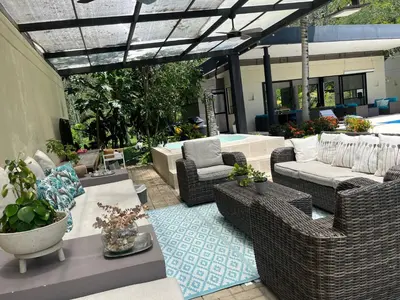 an outdoor patio with wicker chairs and tables at Finca La Siria vista Cerro Tusa in Amagá