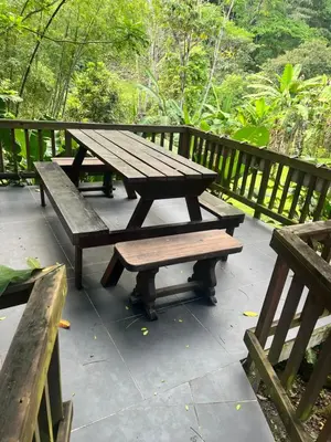 a wooden picnic table and benches on a deck at Finca La Siria vista Cerro Tusa in Amagá