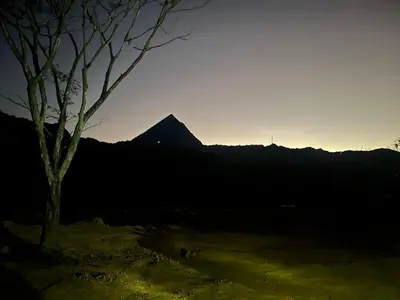 a tree in front of a mountain at sunset at Finca La Siria vista Cerro Tusa in Amagá