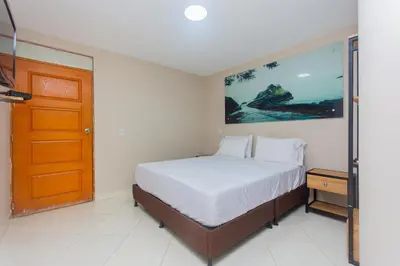 a bedroom with a bed and a wooden door at Hotel Tropical San Jeronimo in San Jerónimo