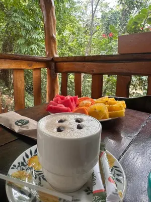 a cup of coffee sitting on a table with fruit at Hotel Tropical San Jeronimo in San Jerónimo