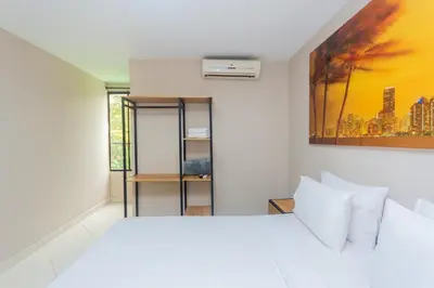 a bedroom with a white bed and a painting on the wall at Hotel Tropical San Jeronimo in San Jerónimo
