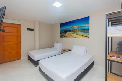 a hotel room with two beds and a door at Hotel Tropical San Jeronimo in San Jerónimo