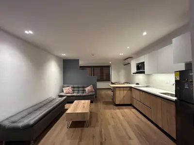 a kitchen and living room with a couch and a table at Acogedor Apto a pasos del metro de Medellín zona centro in Medellín