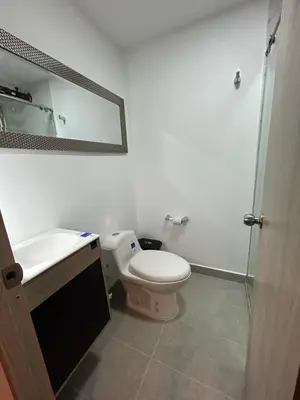 a bathroom with a toilet and a sink and a mirror at Acogedor Apto a pasos del metro de Medellín zona centro in Medellín