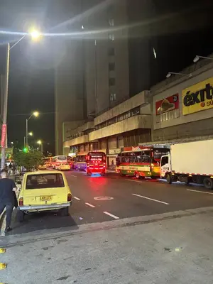 a city street at night with cars and buses at Acogedor Apto a pasos del metro de Medellín zona centro in Medellín