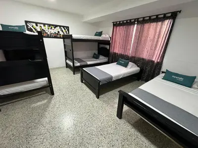 a room with two beds and a bunk bed at Hotel JC 43 in Medellín