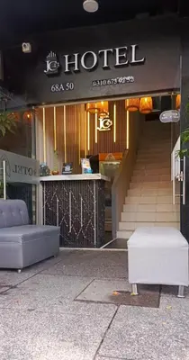 a hotel entrance with a bench in front of a building at Hotel JC 43 in Medellín
