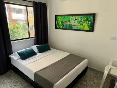 a bed in a room with a window and a bed sidx sidx sidx at Hotel JC 43 in Medellín