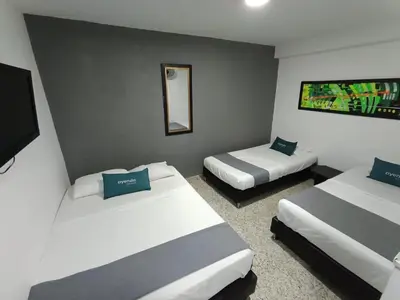 a hotel room with two beds and a mirror at Hotel JC 43 in Medellín