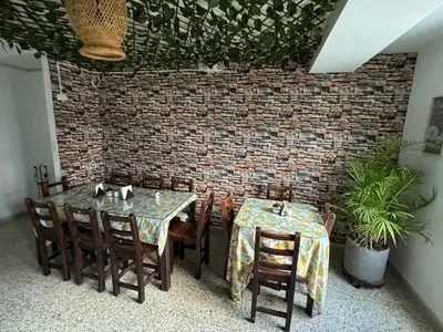 a dining room with a table and chairs and a brick wall at Hotel JC 43 in Medellín