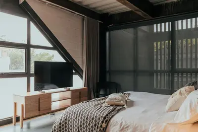 a bedroom with a bed with a tv and a large window at Zeta Erre Apartments in Medellín