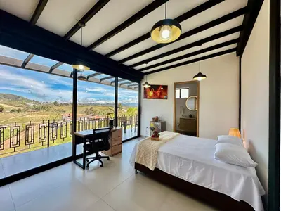 a bedroom with a bed and a large window at Fénix in Marinilla