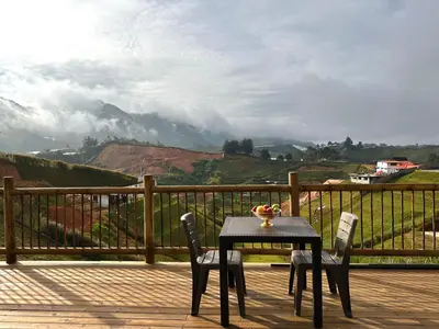 a table and two chairs on a deck with a view at Fénix in Marinilla