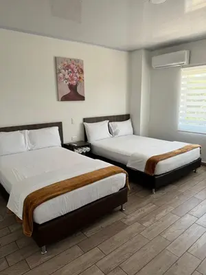 a bedroom with two beds and a window at Hotel FENIX in Doradal