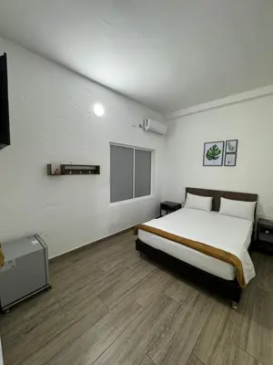a bedroom with a bed and a flat screen tv at Hotel FENIX in Doradal