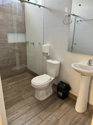 a bathroom with a toilet and a sink and a shower at Hotel FENIX in Doradal