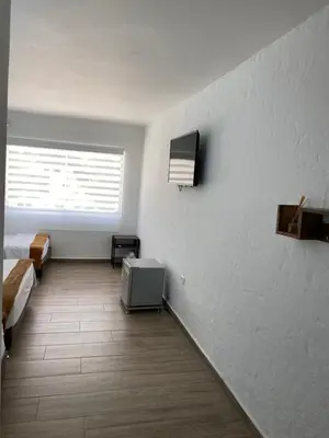 a room with two beds and a tv on a wall at Hotel FENIX in Doradal