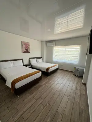 a hotel room with two beds and a window at Hotel FENIX in Doradal