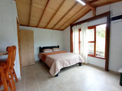 a bedroom with a bed and a large window at Ancestral Cabaña in San Vicente