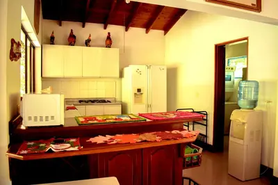 a kitchen with a counter with a microwave and a refrigerator at Villas Mamilú, entrada y salida 100 por ciento flexible in Santa Fe de Antioquia