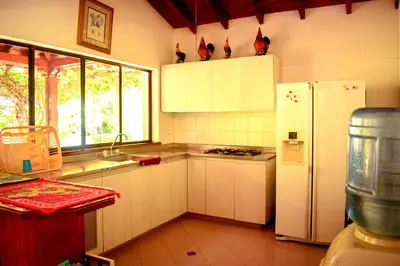 a kitchen with white cabinets and a white refrigerator at Villas Mamilú, entrada y salida 100 por ciento flexible in Santa Fe de Antioquia