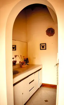 a kitchen with a sink and a counter with an archway at Villas Mamilú, entrada y salida 100 por ciento flexible in Santa Fe de Antioquia