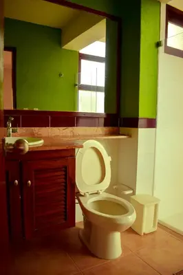 a bathroom with a toilet and a sink and a mirror at Villas Mamilú, entrada y salida 100 por ciento flexible in Santa Fe de Antioquia