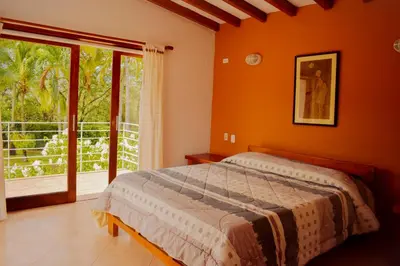 a bedroom with a bed and a large window at Villas Mamilú, entrada y salida 100 por ciento flexible in Santa Fe de Antioquia