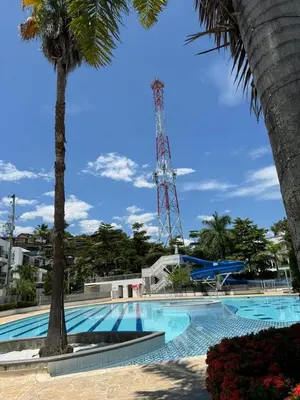 a large swimming pool with palm trees and a tower at Apartasol Ciudadela SantaFe de Antioquia in Santa Fe de Antioquia
