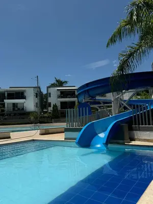 a blue water slide in a swimming pool at Apartasol Ciudadela SantaFe de Antioquia in Santa Fe de Antioquia