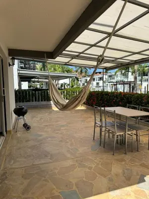 a patio with a hammock and a table and chairs at Apartasol Ciudadela SantaFe de Antioquia in Santa Fe de Antioquia