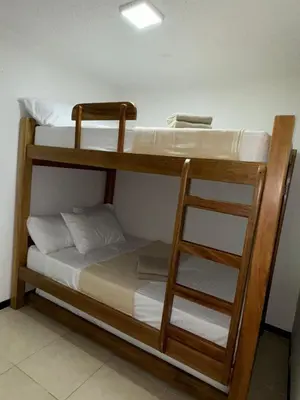 two bunk beds in a room with a ladder at Apartasol Ciudadela SantaFe de Antioquia in Santa Fe de Antioquia