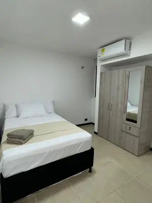 a bedroom with a large bed and a mirror at Apartasol Ciudadela SantaFe de Antioquia in Santa Fe de Antioquia