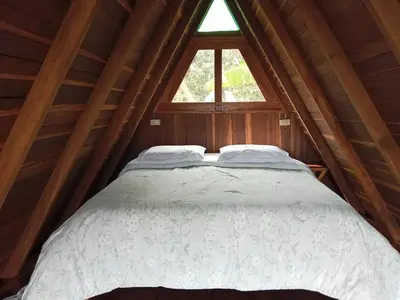 a bed in a wooden room with a window at Cabaña en Jericó in Jericó
