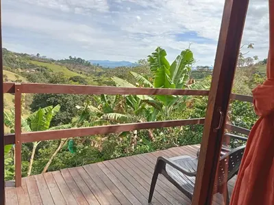 a wooden deck with a chair and a view of a field at Cabaña en Jericó in Jericó