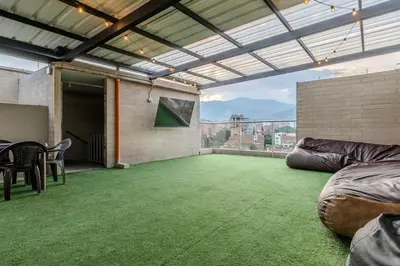 a large room with a green carpeted floor and a patio at Apartamento en Laureles, con piscina y parquedero 401 in Medellín