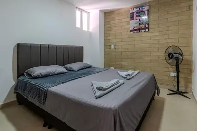 a bedroom with a bed with two shoes on it at Apartamento en Laureles, con piscina y parquedero 401 in Medellín