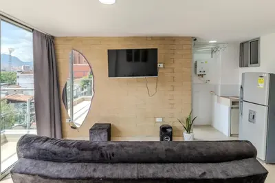 a living room with a large couch in front of a wall at Apartamento en Laureles, con piscina y parquedero 401 in Medellín
