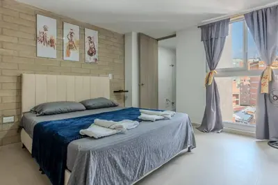a bedroom with a large bed with towels on it at Apartamento 2BR Parqueadero y Piscina 502 in Medellín