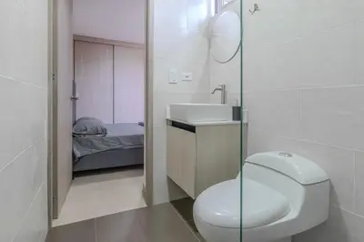 a bathroom with a toilet and a sink and a bed at Apartamento 2BR Parqueadero y Piscina 502 in Medellín