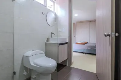 a white bathroom with a toilet and a sink at Apartamento 2BR Parqueadero y Piscina 502 in Medellín