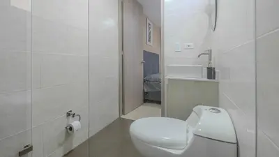 a white bathroom with a toilet and a sink at Apartamento en laureles con piscina y parqueadero 402 in Medellín