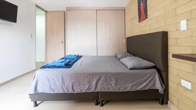 a bed in a room with a brick wall at Apartamento en laureles con piscina y parqueadero 402 in Medellín