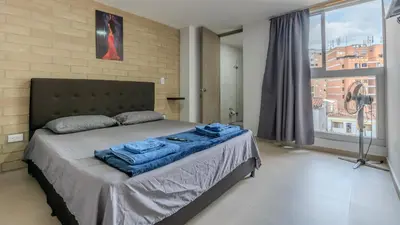 a bedroom with a bed with blue towels on it at Apartamento en laureles con piscina y parqueadero 402 in Medellín