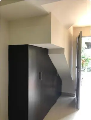 a room with a black cabinet and a staircase at Apartaestudios contiguos cerca al Centro Comercial Fabricato in Bello