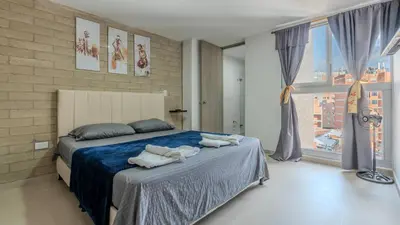 a bedroom with a large bed with towels on it at Apartamento en laureles con piscina, parqueadero 302 in Medellín