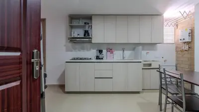 a kitchen with white cabinets and a counter top at Apartamento en laureles con piscina, parqueadero 302 in Medellín