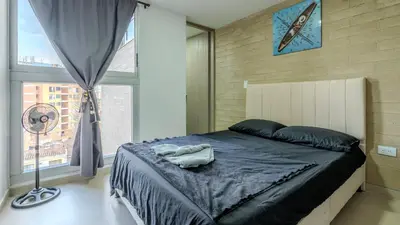 a bedroom with a large bed with a clock on the wall at Apartamento en laureles con piscina, parqueadero 302 in Medellín